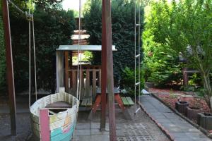 a swing in a garden with a boat at Pension zur Neiße in Guben