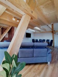 a living room with a blue couch and wooden ceilings at Alte Försterei Goldbeck in Rinteln