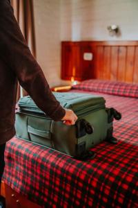 拉戈普艾羅的住宿－卡瓦尼亞斯諾索特羅斯山林小屋，一位身着行李的双床的人