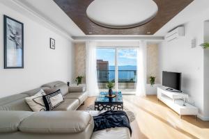 a living room with a couch and a tv at Luxury Villa Lucas with heated pool, whirlpool, sauna, 14 pax in Podstrana