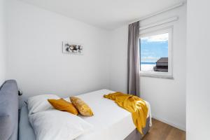 a bedroom with a bed with yellow pillows and a window at Luxury Villa Lucas with heated pool, whirlpool, sauna, 14 pax in Podstrana +62 photos