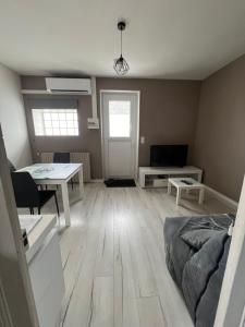 a living room with a bed and a table at Joli T2 1er étage wifi clim près de l'hôpital in Issoudun