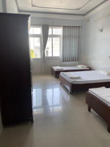 Habitación con 3 camas y ventana en Khách sạn Tường Minh en Cao Lãnh