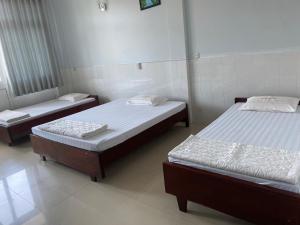 a room with two beds in a room at Khách sạn Tường Minh in Cao Lãnh