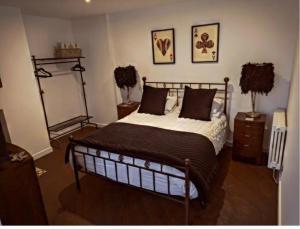 1 dormitorio con 1 cama y 2 cuadros en la pared en The Beulah Apartments, en Leeds