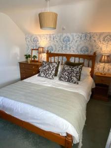 una camera da letto con un letto con cuscini sopra di The Wheelhouse at Hewish Mill a Bittadon