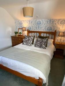 a bedroom with a bed with pillows on it at The Wheelhouse at Hewish Mill in Bittadon