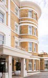 un grande edificio in mattoni con un cartello che legge la locanda di The Nici a Bournemouth