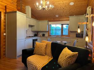 a living room with a couch and a kitchen at Romantic Log Cabin With Hot Tub in Leominster