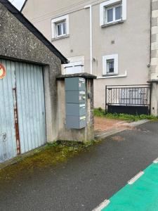 a building with a gate and a garage at Joli T2 1er étage wifi clim près de l'hôpital in Issoudun