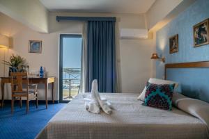 アテネにあるフォー シーズンズ ホテルのベッド、デスク、バルコニーが備わるホテルルームです。
