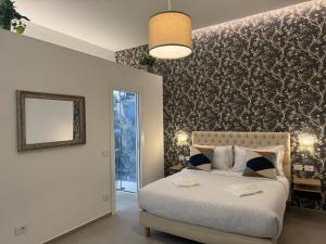 a bedroom with a white bed and a wall with a pattern at Lina suites & rooms in La Spezia