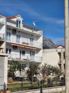 un edificio de apartamentos con balcones y una valla en Josip, en Kaštela