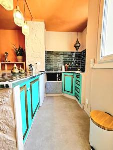 cocina con armarios verdes y encimera en suite orientale du vieux port, en Marsella