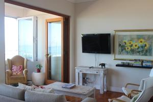 sala de estar con sofá y TV en Harbour Views, en Kalk Bay