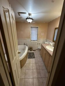 a bathroom with a tub and a sink and a bath tub at Beautiful Private Room Near Restaurants Shopping and Transit P1 in Pickering