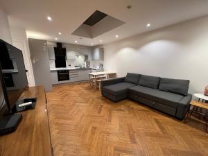 a living room with a couch and a kitchen at Hassocks House - Modern Detached 2 Bedroom House in Streatham in Streatham Vale