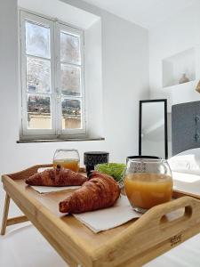 - une table avec deux croissants et un verre de jus d'orange dans l'établissement Le Iéna, à Carcassonne