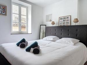 - une chambre avec un grand lit blanc et 2 oreillers dans l'établissement Le Iéna, à Carcassonne