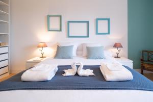 two towels on a bed with two swans on it at Évasions-Escapade, centre-ville, gare in Auterive