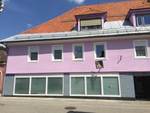 ein rosafarbenes und violettes Gebäude auf einer Straße in der Unterkunft Haus Weisses Lamm in Weitensfeld