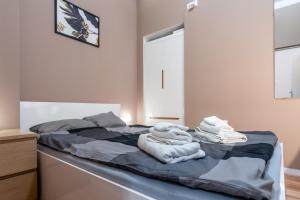 um quarto com uma cama com toalhas em Main Square Teatralna - 2 room apartment with balcony - self-in - coffee and tea em Katowice