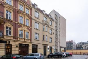 um edifício com carros estacionados em frente em Main Square Teatralna - 2 room apartment with balcony - self-in - coffee and tea em Katowice