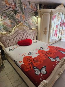 Schlafzimmer mit einem Bett mit roten Rosen und Schmetterlingen in der Unterkunft Willa Magdalena in Świnoujście