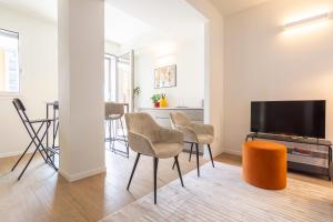 uma sala de estar com uma mesa e cadeiras e uma televisão de ecrã plano em CaseOspitali - Glam Flat, nuovo trilocale di design zona Prada con box em Milão