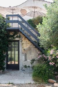Una escalera con una sombrilla junto a una puerta en La Madeleine Arles, en Arles
