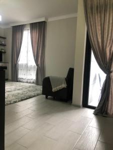 a living room with two large windows and a couch at Квартира на море Батуми in Makhinjauri