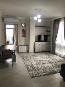 a living room with a table and a rug at Квартира на море Батуми in Makhinjauri