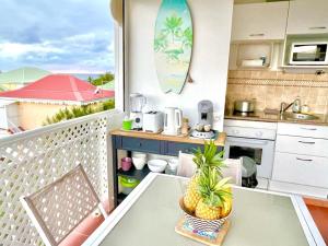 a balcony with a table and a kitchen at Résidence Anse des Rochers Guadeloupe Saint-François - quart de villa vue mer avec citerne et wifi privés in Saint-François