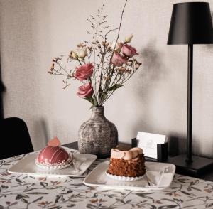 a table with two cakes and a vase with flowers at B&B de Plattelandshoeve in Rhenen