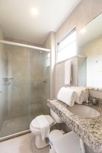 a bathroom with a shower and a sink and a toilet at Duro Beach Garden Hotel in Cumbuco