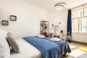 een slaapkamer met een bed met een blauwe deken erop bij Cozy apartment near parks in Žižkov by Prague Days in Praag