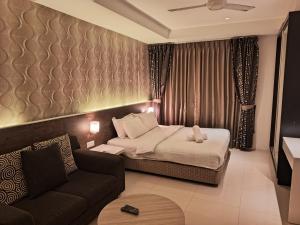 une chambre d'hôtel avec un lit et un canapé dans l'établissement Taragon starlight, à Kuala Lumpur