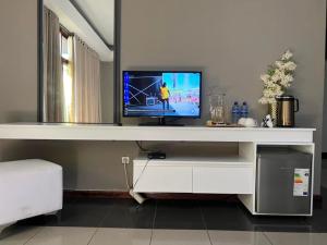 a tv sitting on top of a white shelf at CASA AZUL ACCOMMODATION in Matola