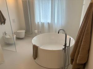baño blanco con bañera y aseo en BG home, en Radwanice