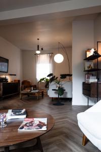 a living room with a table and a couch at Maison Grand Sable in Veules-les-Roses