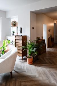 a living room with potted plants on the floor at Maison Grand Sable in Veules-les-Roses