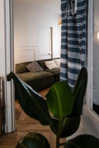 sala de estar con sofá y silla verde en Maison Grand Sable, en Veules-les-Roses