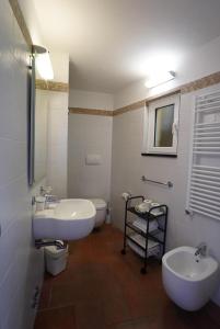 a bathroom with two sinks and a toilet and a mirror at Locanda Ca Da Iride in Riomaggiore