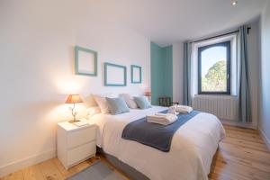 1 dormitorio con 1 cama blanca grande y ventana en Auterive-Évasions-Escapade-parking, hypercentre, gare en Auterive