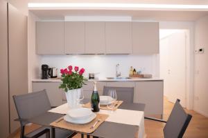 Una cocina y un comedor con mesa y sillas. en Romantic White Apartment - 5 minutes from the lake, en Como