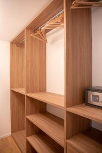 armario con estanterías de madera y TV en Romantic White Apartment - 5 minutes from the lake, en Como