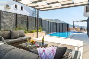 a patio with a couch and a table next to a swimming pool at Pearl Apart in Kas