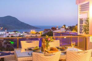 a table with food and wine glasses on a balcony at Pearl Apart in Kas