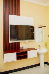uma casa de banho com um lavatório e um espelho em Blanket Suites em Kampala