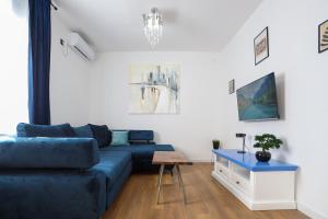 a living room with a blue couch and a table at DreamLand Apartment in Surčin